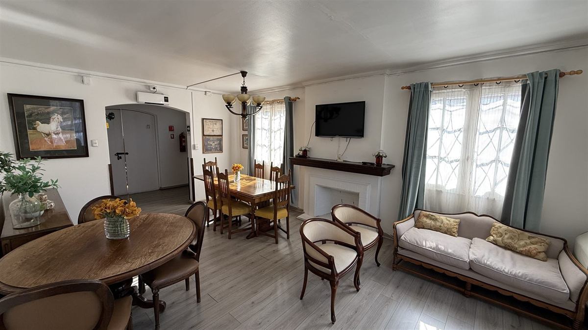Living de Casa Menar con sillones, chimenea y ventanales